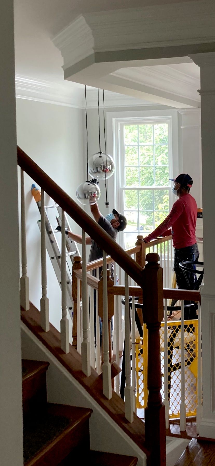 The 4 Brothers crew painting a stairwell in an Arlington, VA home